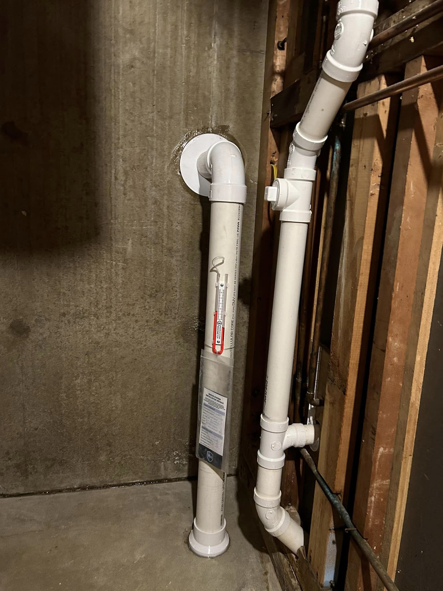 Radon vent pipe with a U-tube manometer in a basement